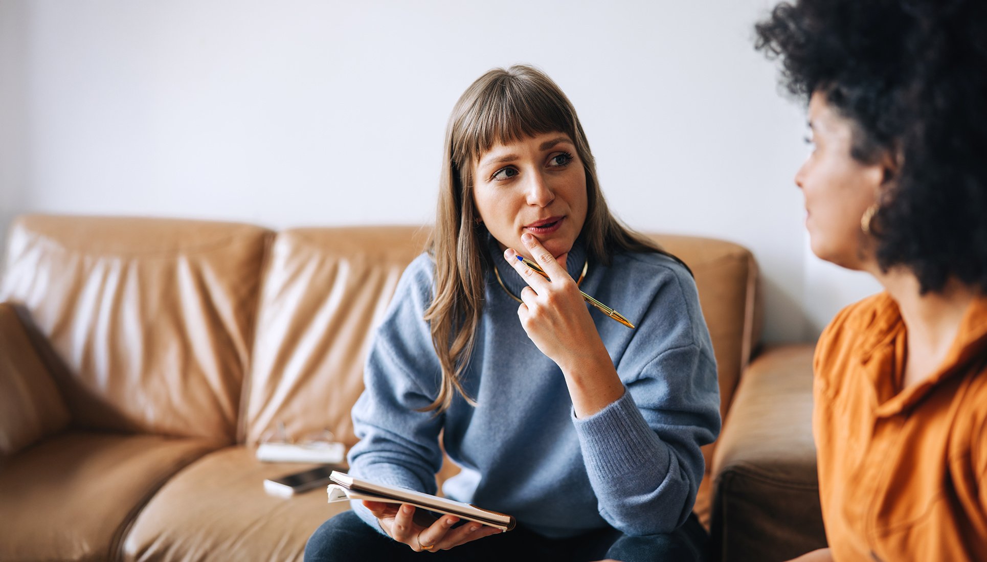 Two people discussing something they are writing on a tablet