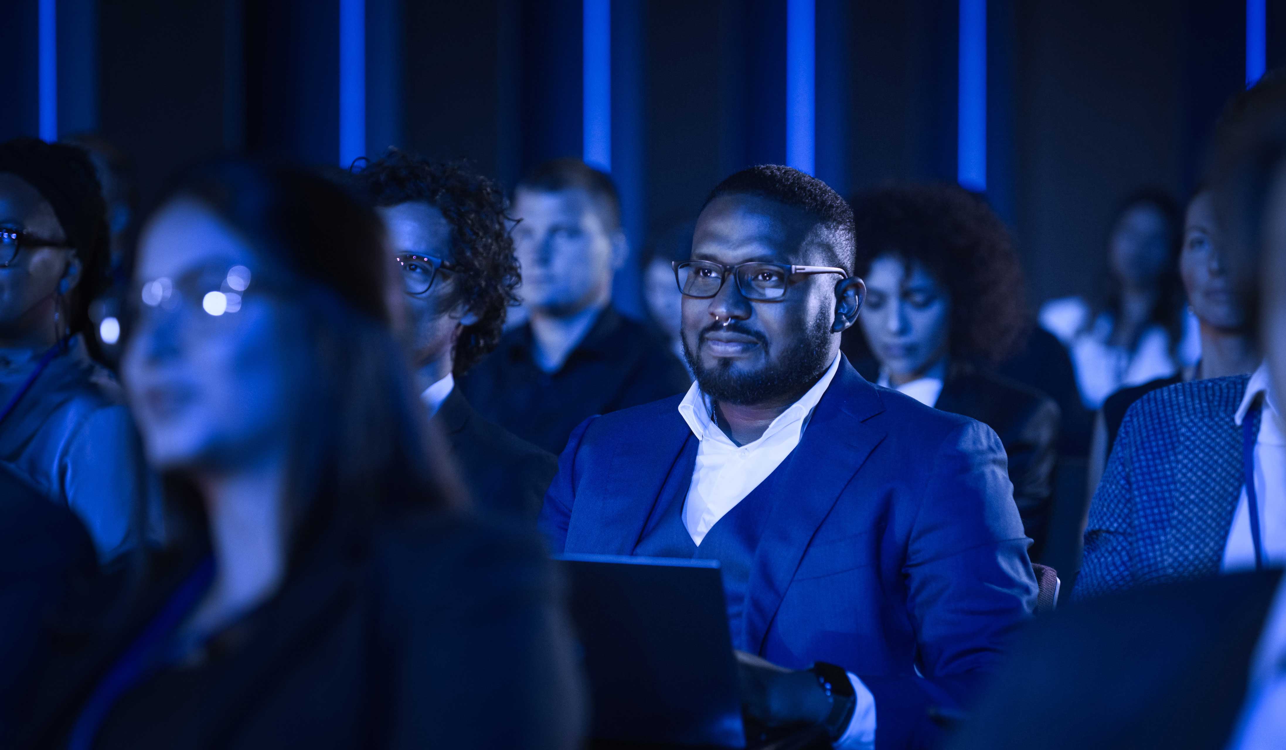 man at a conference with his laptop 